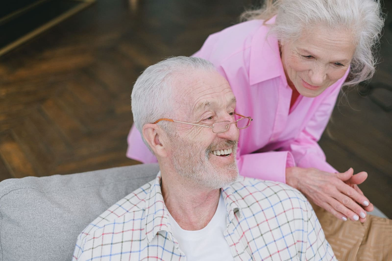 An older couple at home together, mid conversation and relaxed.